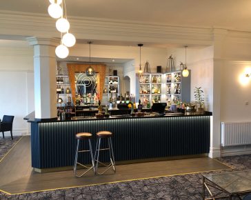 Dark blue bar area with two bar stools