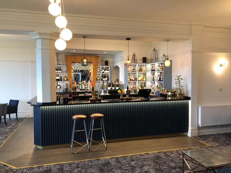Dark blue bar area with two bar stools