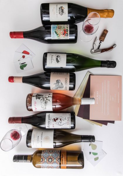 Selection of wines laying down in a white table.